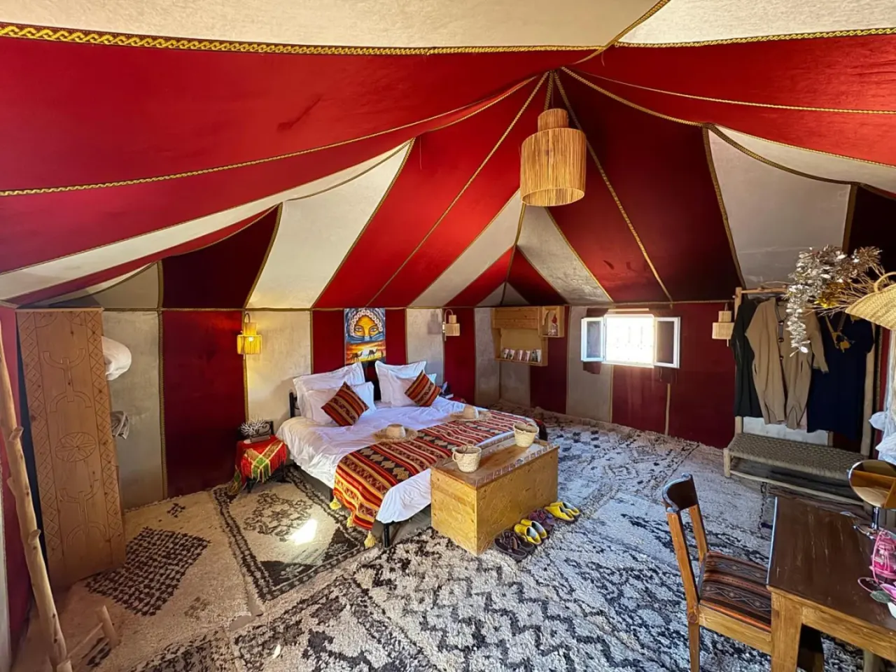 Chambre tente de luxe à Maria'S Luxury Camp à Merzouga avec un lit double, des tapis colorés et un décor de camp du désert