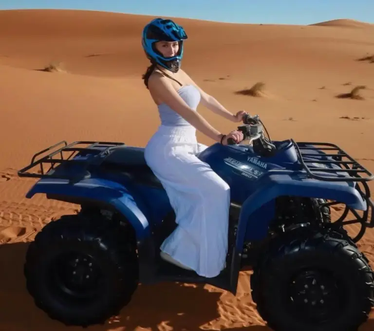 Femme assise sur un quad bleu dans le désert près de Maria'S Luxury Camp à Merzouga