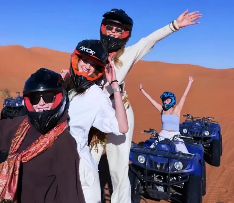 Des clients portant des casques sur des quads dans le désert près de Maria'S Luxury Camp à Merzouga