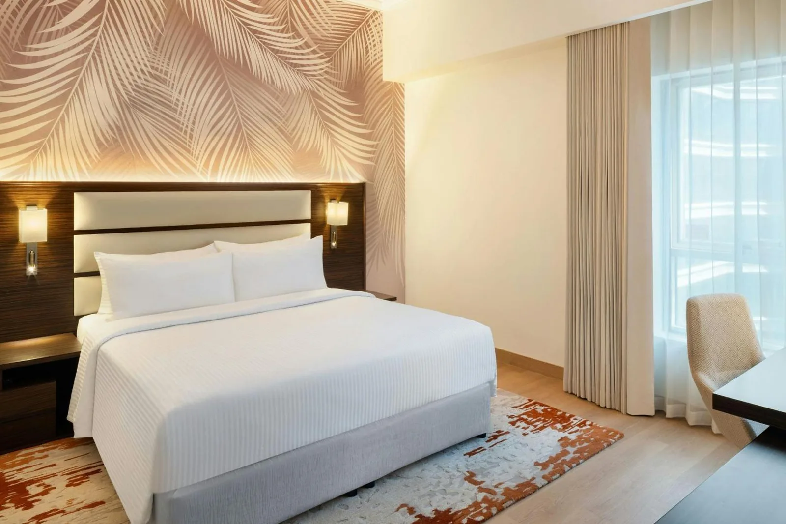 Kingsize-Schlafzimmer im Marriott Hotel Production City, Dubai mit gemusterter Akzentwand und modernem Dekor