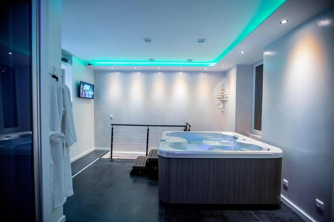 MeandYou Hammametspa – hotel en Colmar, France – un dormitorio con una cama y un sofá de cuero negro en MeandYou Hammametspa en Colmar