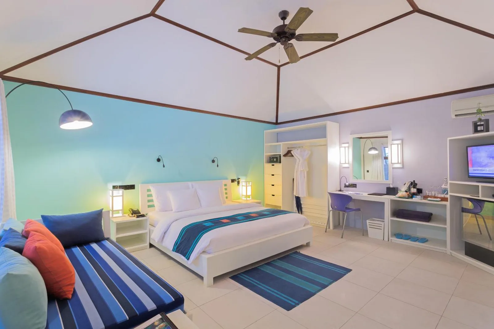 Innenansicht eines Deluxe-Zimmers im Meeru Maldives Resort mit lebendigen Farben