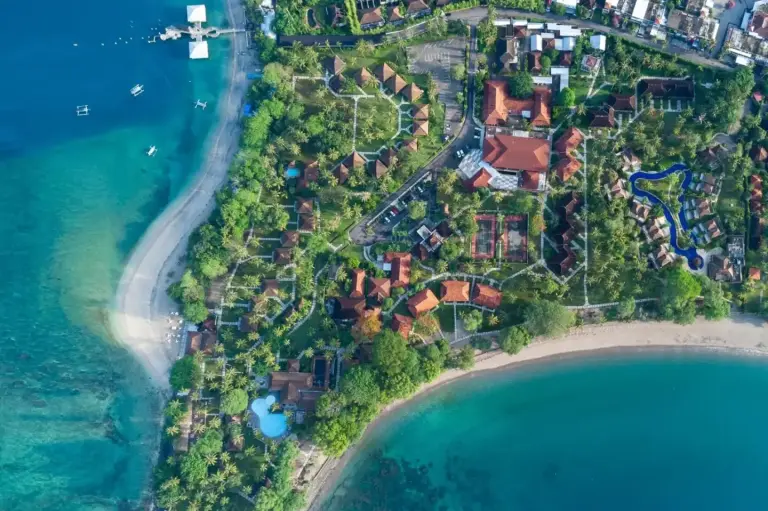Vista aérea de Merumatta Senggigi Lombok en Mataram que muestra la distribución del resort frente a la playa y la costa tropical