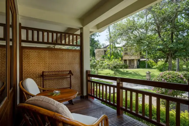 Balcón privado en Merumatta Senggigi Lombok en Mataram con sillas y vistas al jardín
