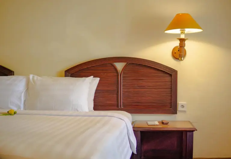 Primer plano de una cama y una lámpara de noche en una habitación de Merumatta Senggigi Lombok, Mataram