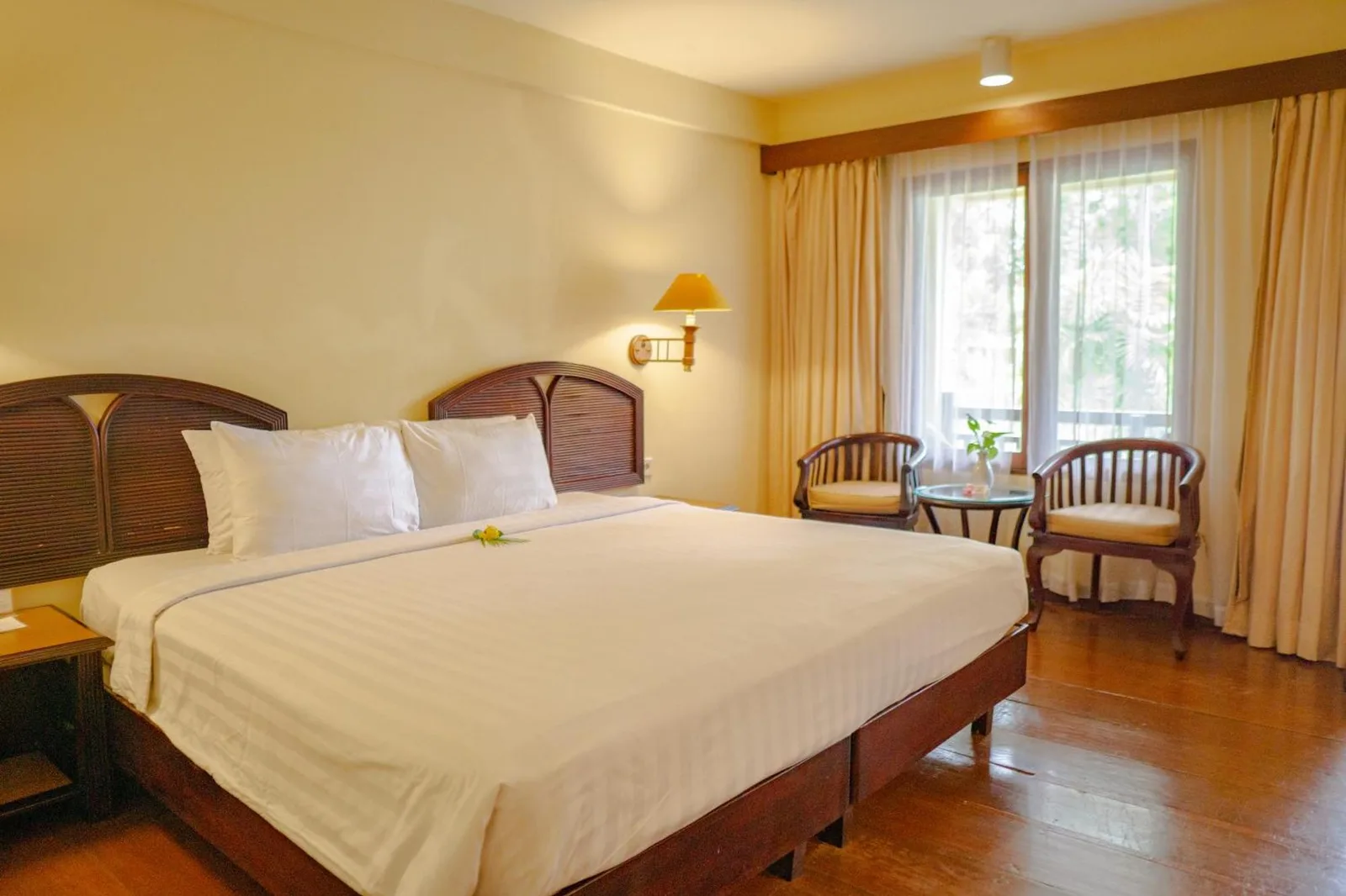 Habitación de huéspedes en Merumatta Senggigi Lombok en Mataram con una cama doble y zona de estar junto a la ventana