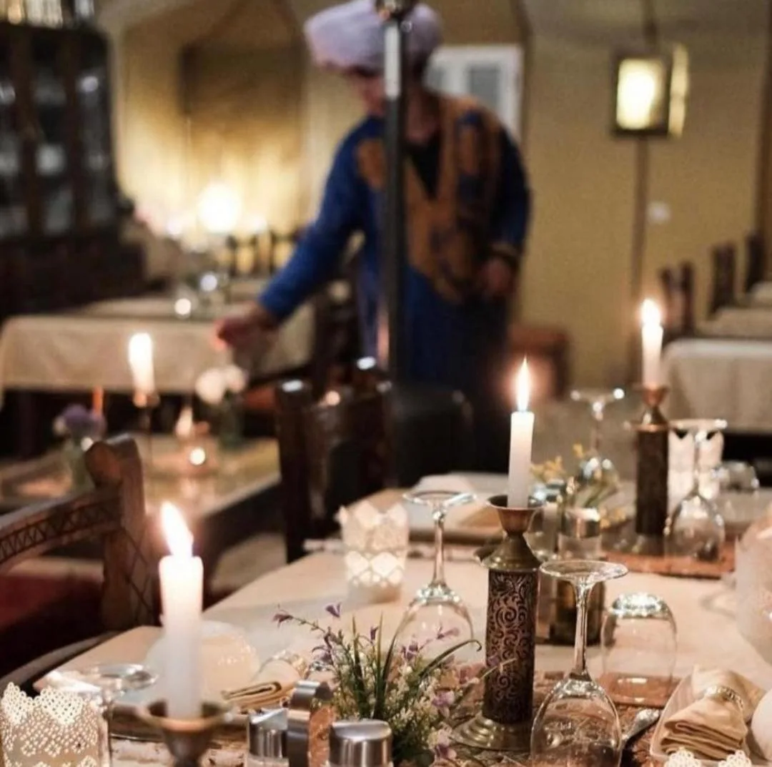 Montaje de cena a la luz de las velas en Merzouga Alicante Luxury Camp en Merzouga con decoración de mesa de estilo marroquí