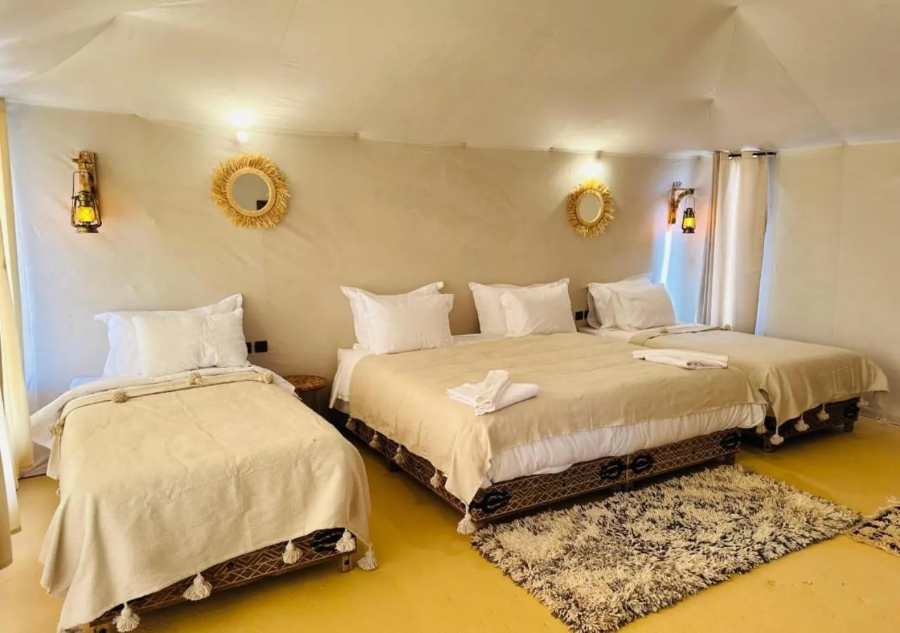 Merzouga Authentic Camp – Hotel in Merzouga, Marokko – ein Schlafzimmer mit zwei Betten und einem Spiegel an der Wand im Merzouga Authentic Camp in Merzouga