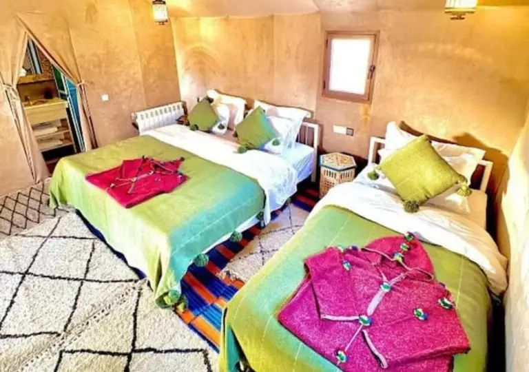 Merzouga Authentic Camp – Hotel in Merzouga, Marokko – ein Schlafzimmer mit zwei Betten mit gelben Bettlaken im Merzouga Authentic Camp in Merzouga