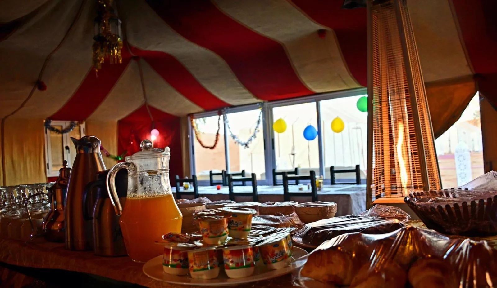 Frühstücksbuffet im Merzouga Berber Camp in Merzouga mit Saft, Gebäck und Tischen in einem traditionellen Zelt