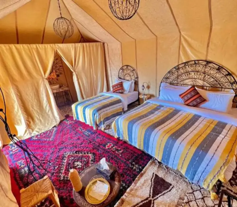 Ein Badezimmerbereich mit eigenem Bad im Merzouga Berbers Luxury Camp mit Dusche und Waschbecken in Merzouga.