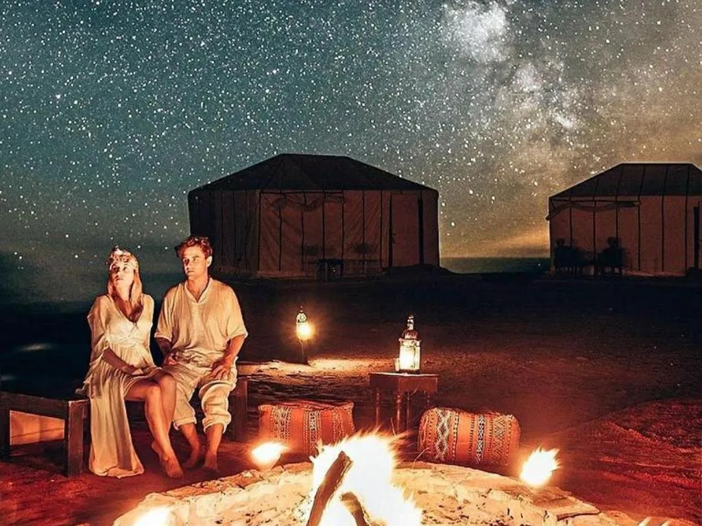 Pareja disfrutando de la noche estrellada en Merzouga Cool Luxury Camp