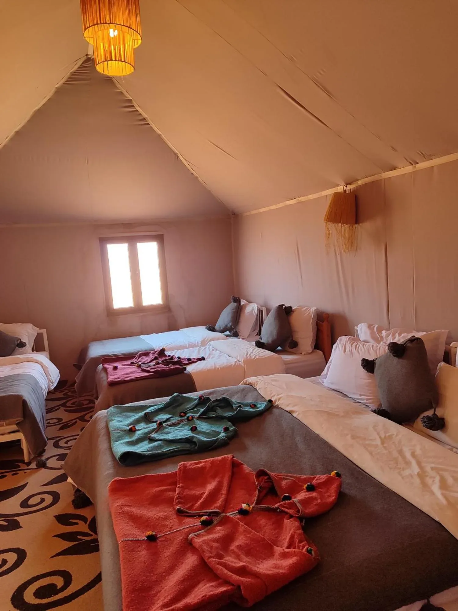 Interior view of orange tent at Merzouga Desert Luxe Camp