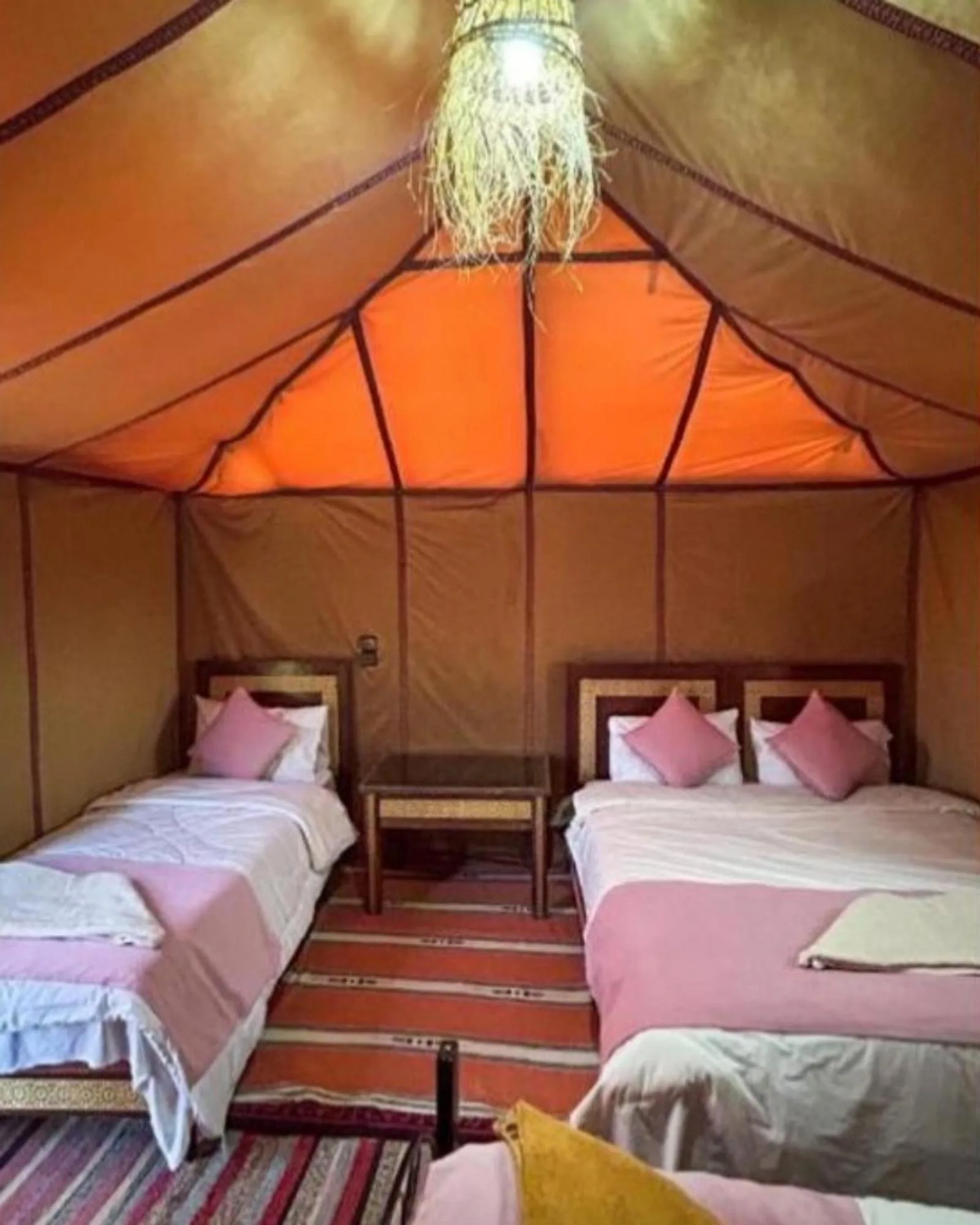 Interior view of orange tent at Merzouga Desert Luxe Camp