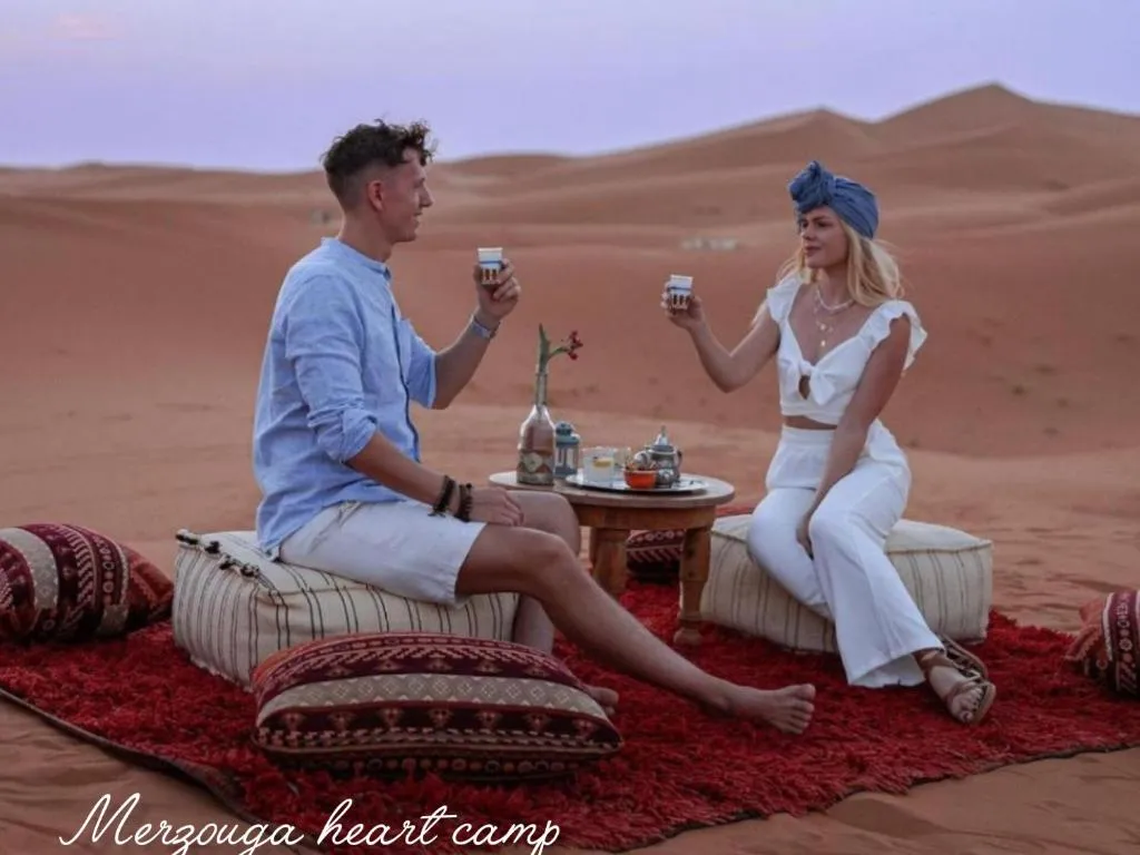 Paar genießt Tee in der Wüste im Merzouga Heart Camp