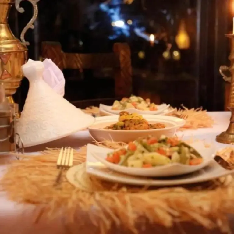 Esstisch im Merzouga Legacy Camp in Merzouga mit angerichteten Speisen und elegantem Tischgedeck