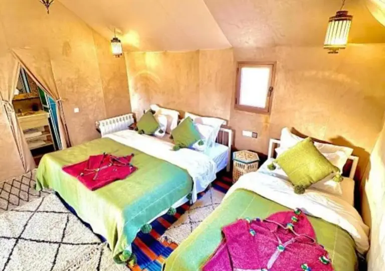 Familien-Zeltzimmer im Merzouga Legacy Camp in Merzouga mit Einzelbetten, heller Bettwäsche und Wüstencamp-Dekor
