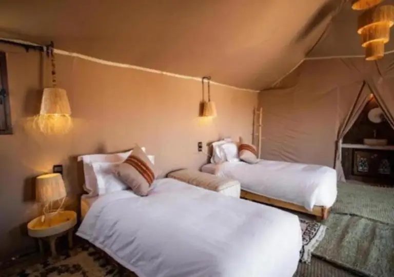 Zweibett-Zeltzimmer im Merzouga Legacy Camp in Merzouga mit zwei Einzelbetten und rustikalem Innendesign