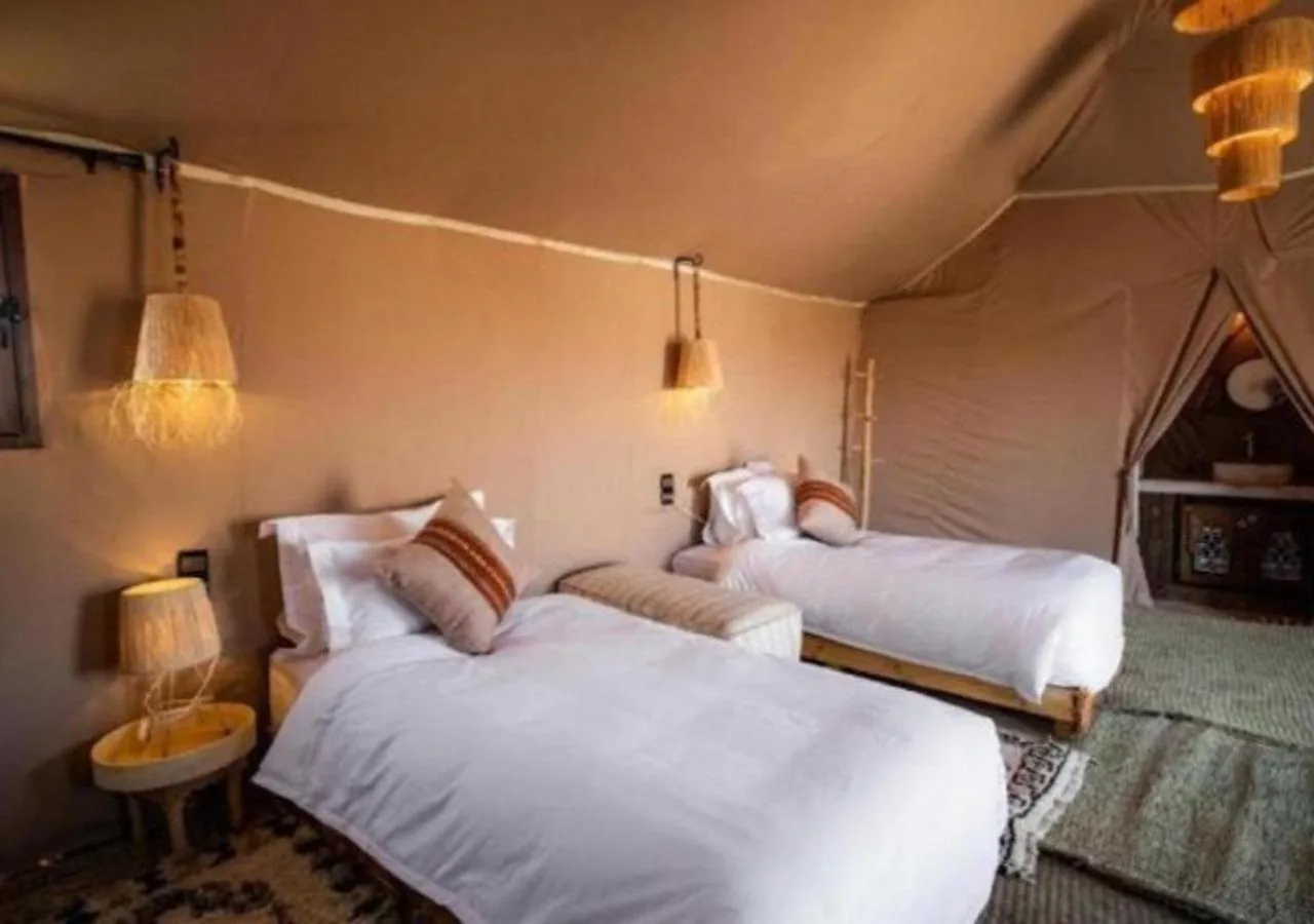 Zweibett-Zeltzimmer im Merzouga Legacy Camp in Merzouga mit zwei Einzelbetten und rustikalem Innendesign