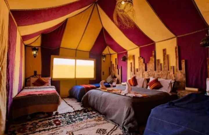 Room in a vibrant tent at Merzouga Luxury Camp
