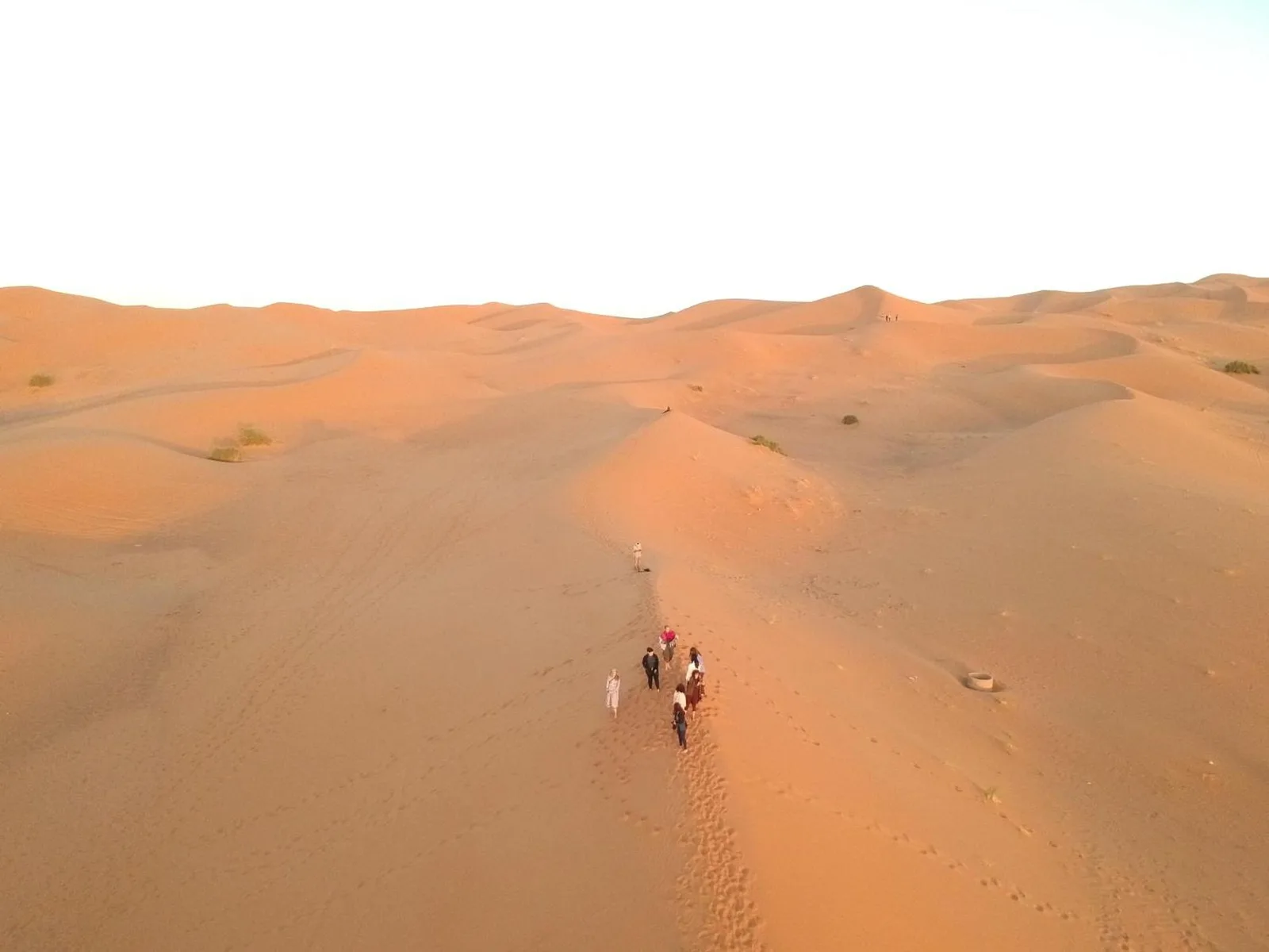 Vista aérea de personas caminando por las dunas del Sáhara cerca de Merzouga Luxury Camping en Merzouga