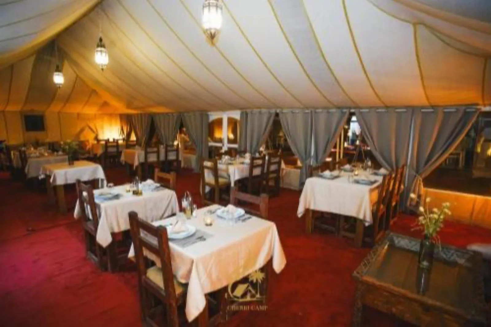Gäste reiten während der Aktivitäten im Merzouga Luxury Tents & Activities auf Kamelen durch die Wüste