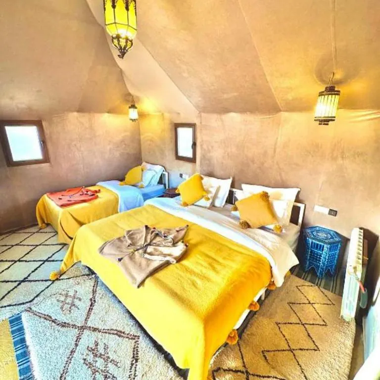 Chambre d'hôte confortable au Merzouga Nomadic Desert Camp avec des lits