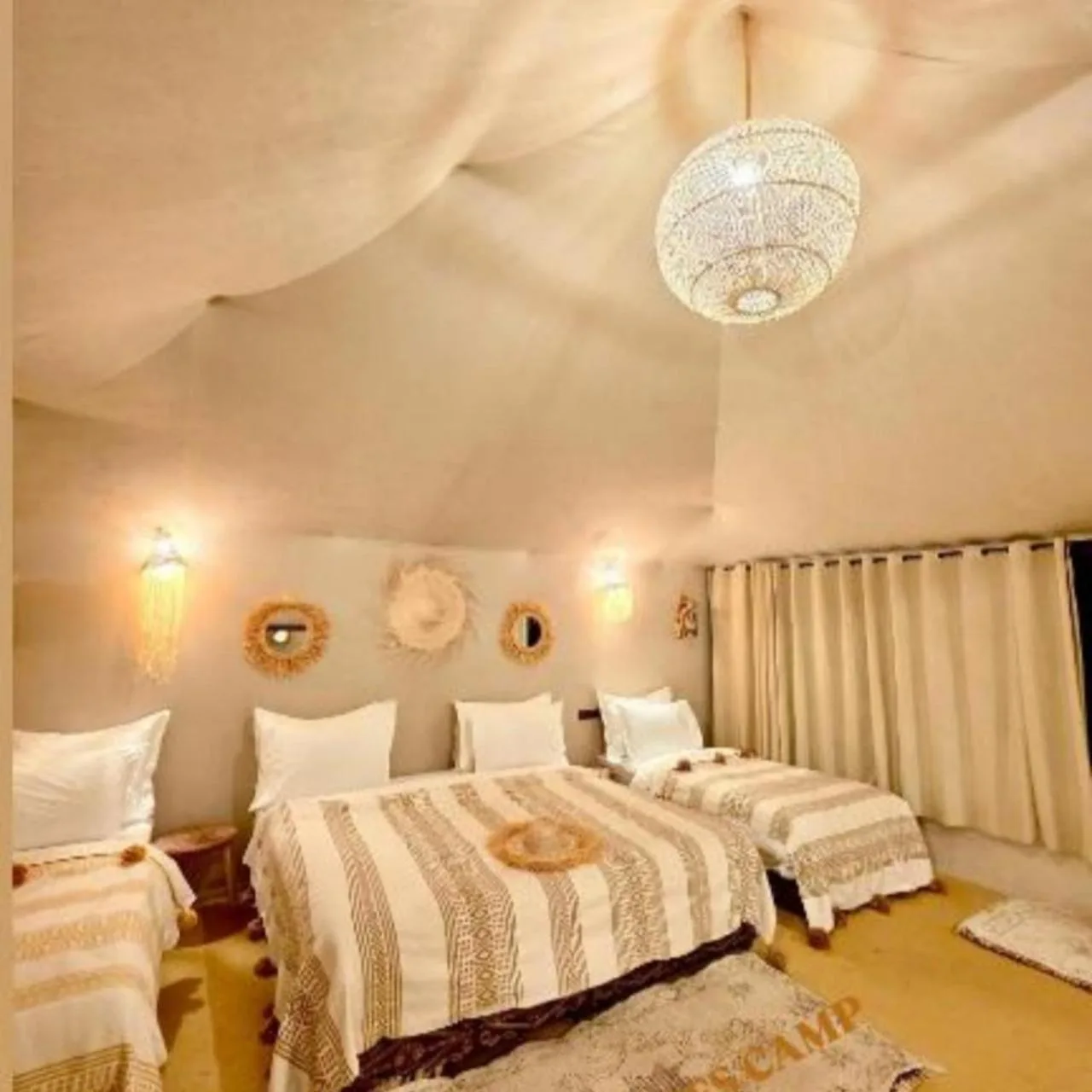 Habitación tienda familiar en Merzouga Royal Camp en Merzouga con varias camas e iluminación decorativa