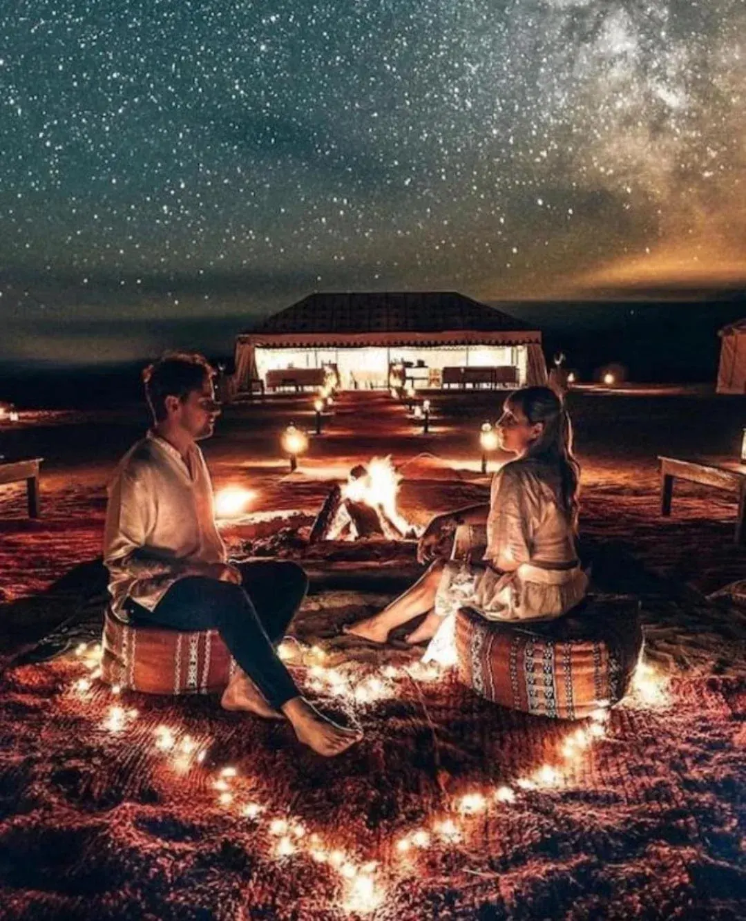 Paar am Lagerfeuer eines Wüstencamps im Merzouga Sara Luxury Camp in Merzouga unter einem sternenklaren Nachthimmel
