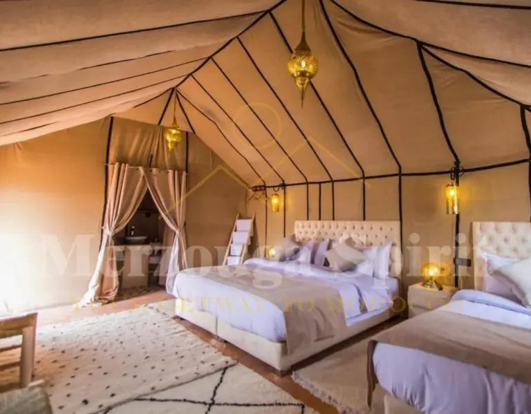 Elegante interior de tienda dormitorio en Merzouga Spirit Luxury Camp en Merzouga con cama grande