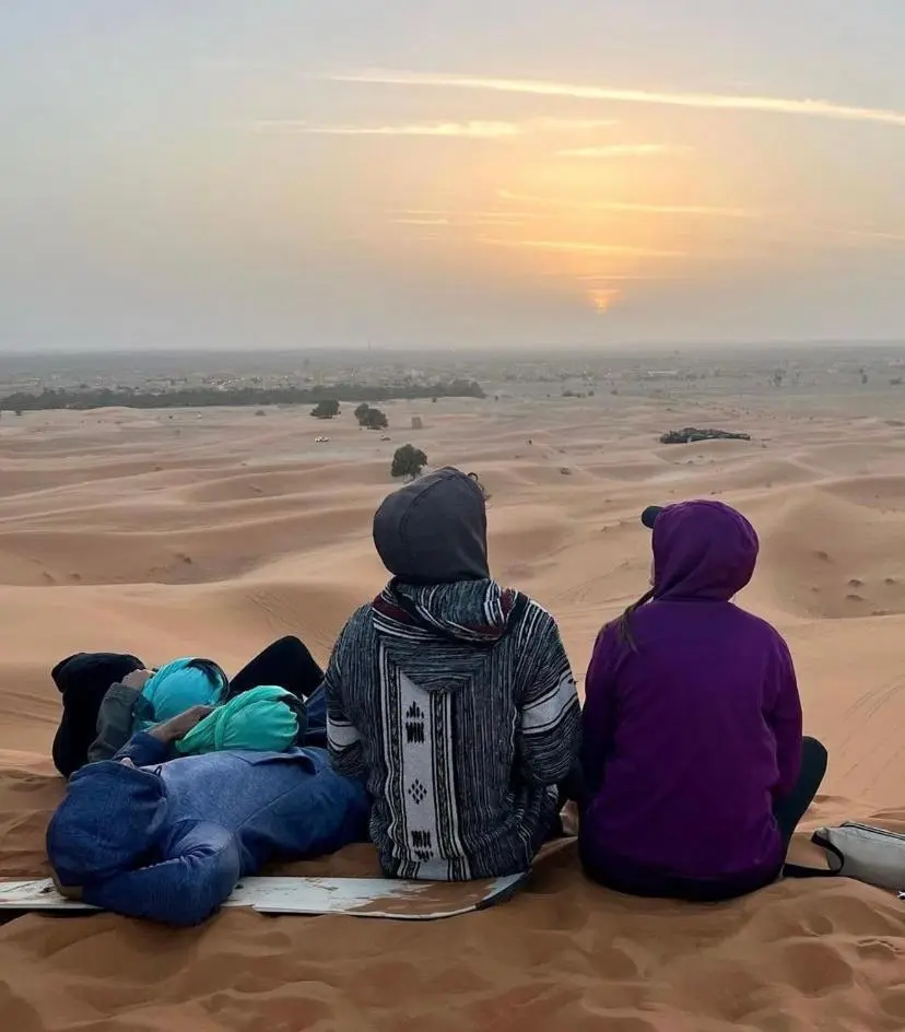 Huéspedes disfrutando de las vistas del atardecer en Merzouga Stars Luxury Camp