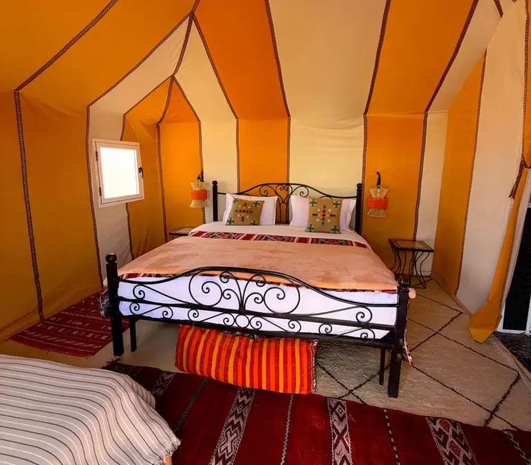 Merzouga Twilight Camp tienda amarilla con ropa de cama elegante
