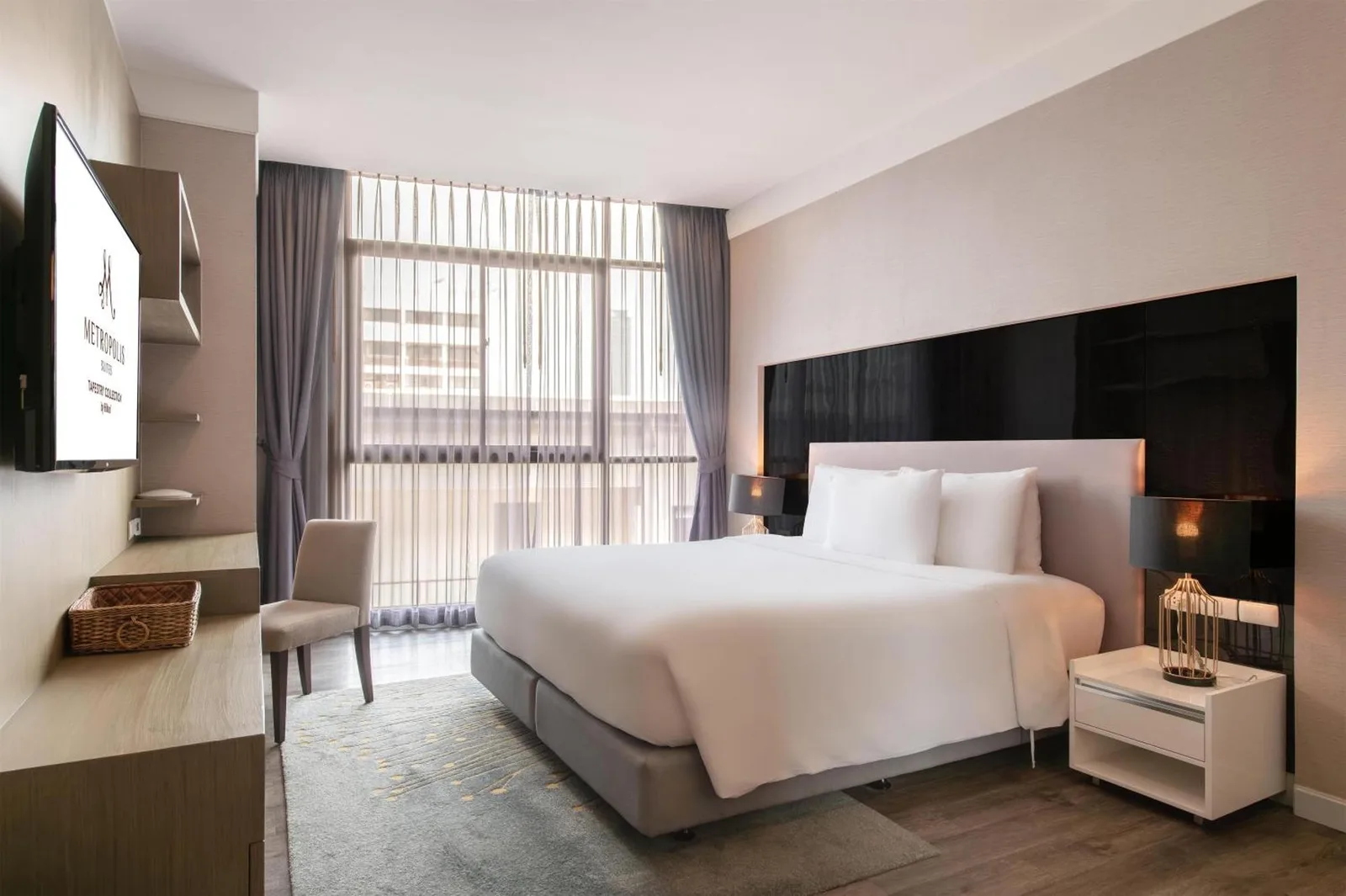 Bright bedroom at Metropolis Suites Bangkok, Tapestry Collection by Hilton with king bed, sheer curtains, and city-facing window