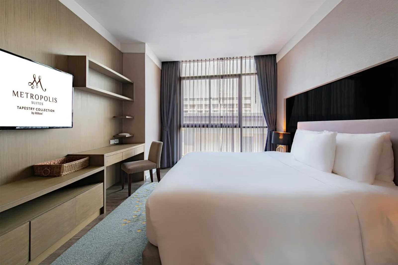 Kitchenette at Metropolis Suites Bangkok, Tapestry Collection by Hilton with refrigerator, microwave, and white cabinetry