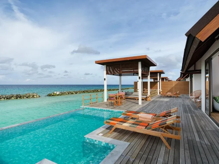 Outdoor pool area at Meyyafushi Maldives with loungers