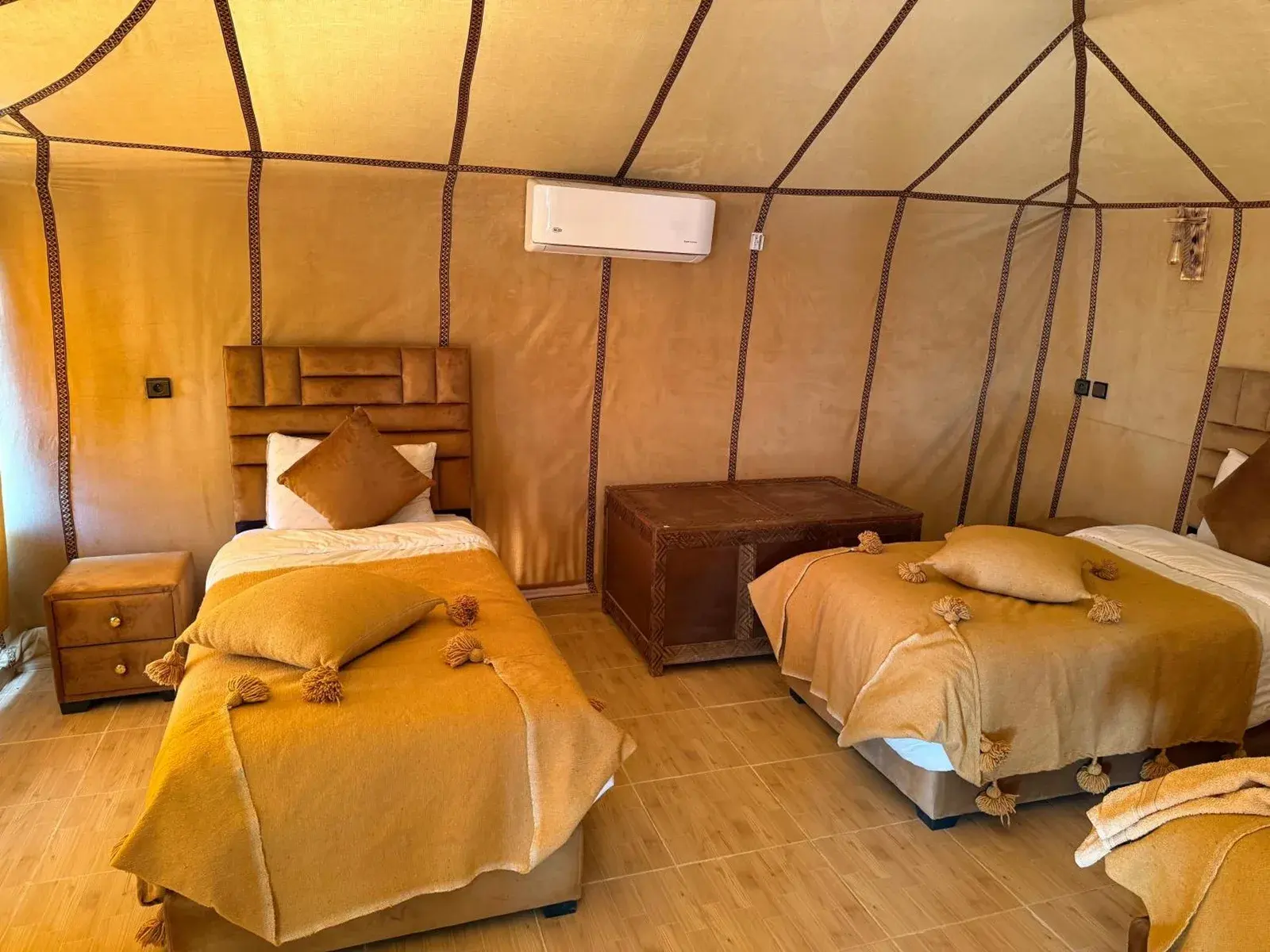 Milagro Luxury Camps in Merzouga tent room with two single beds and warm lighting