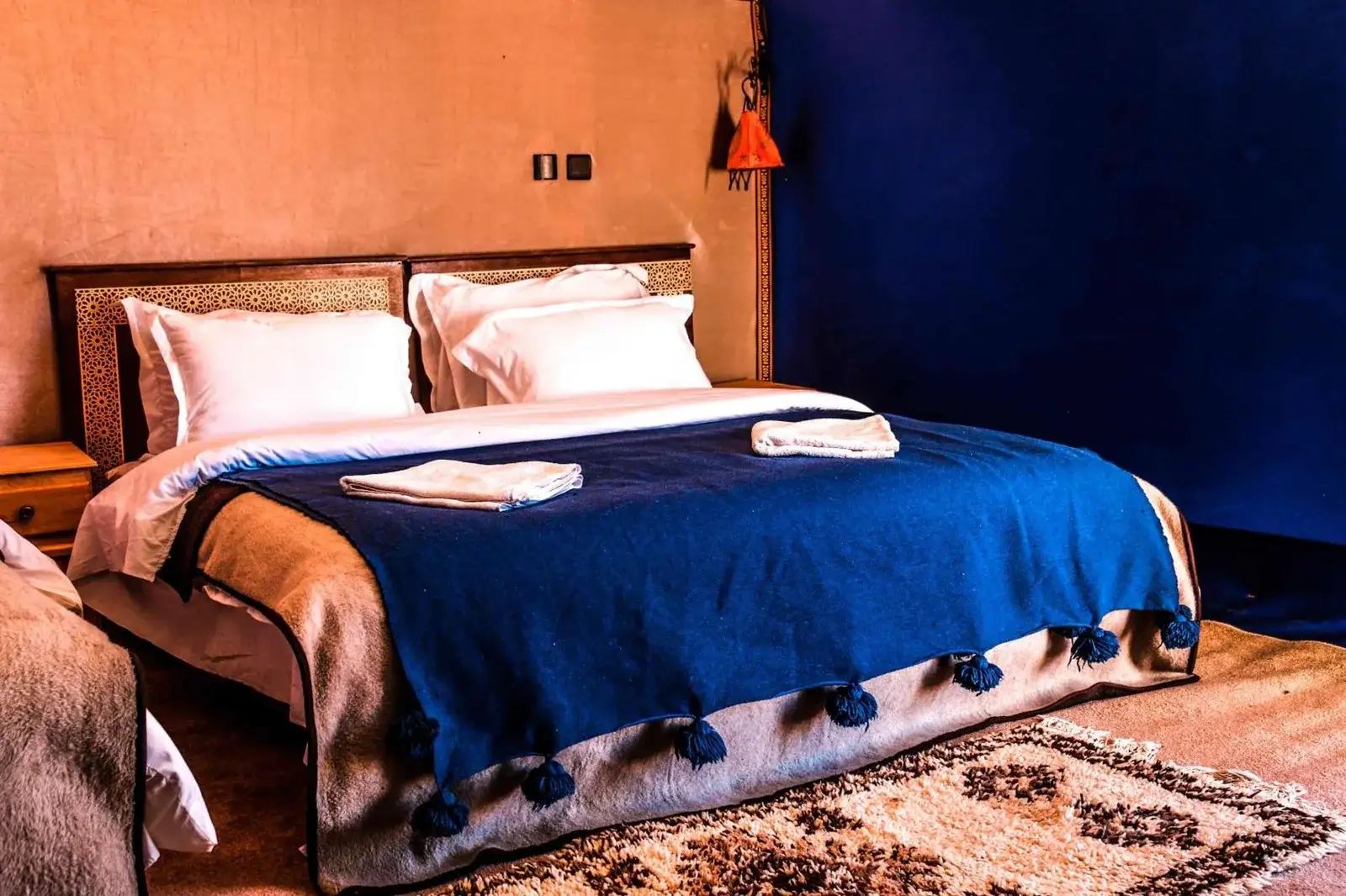 Zimmer mit Doppelbett im Milky Way Desert Camp in Merzouga mit blauer Decke und rustikaler Zeltdekoration
