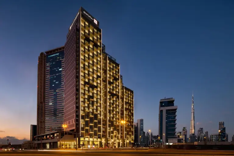 Millennium Atria Business Bay Dubai exterior view at dusk with illuminated tower and city skyline