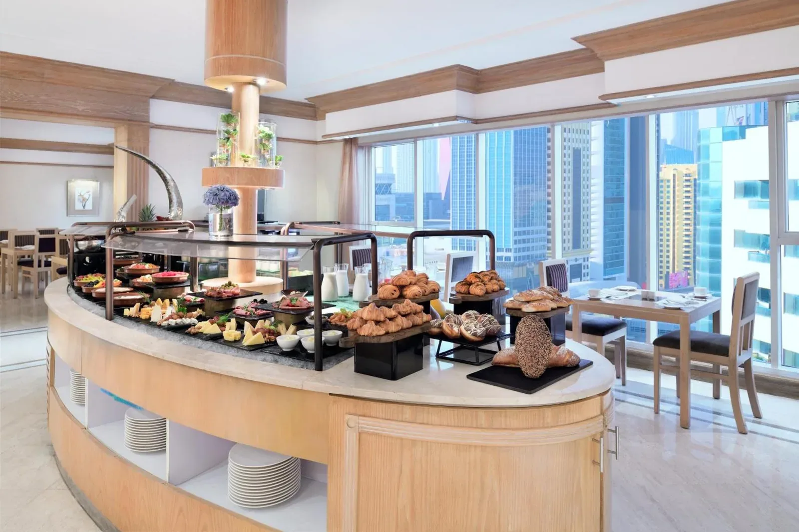 Buffet de petit-déjeuner à Millennium Plaza Downtown, Dubai avec viennoiseries, fruits et vue sur la salle à manger