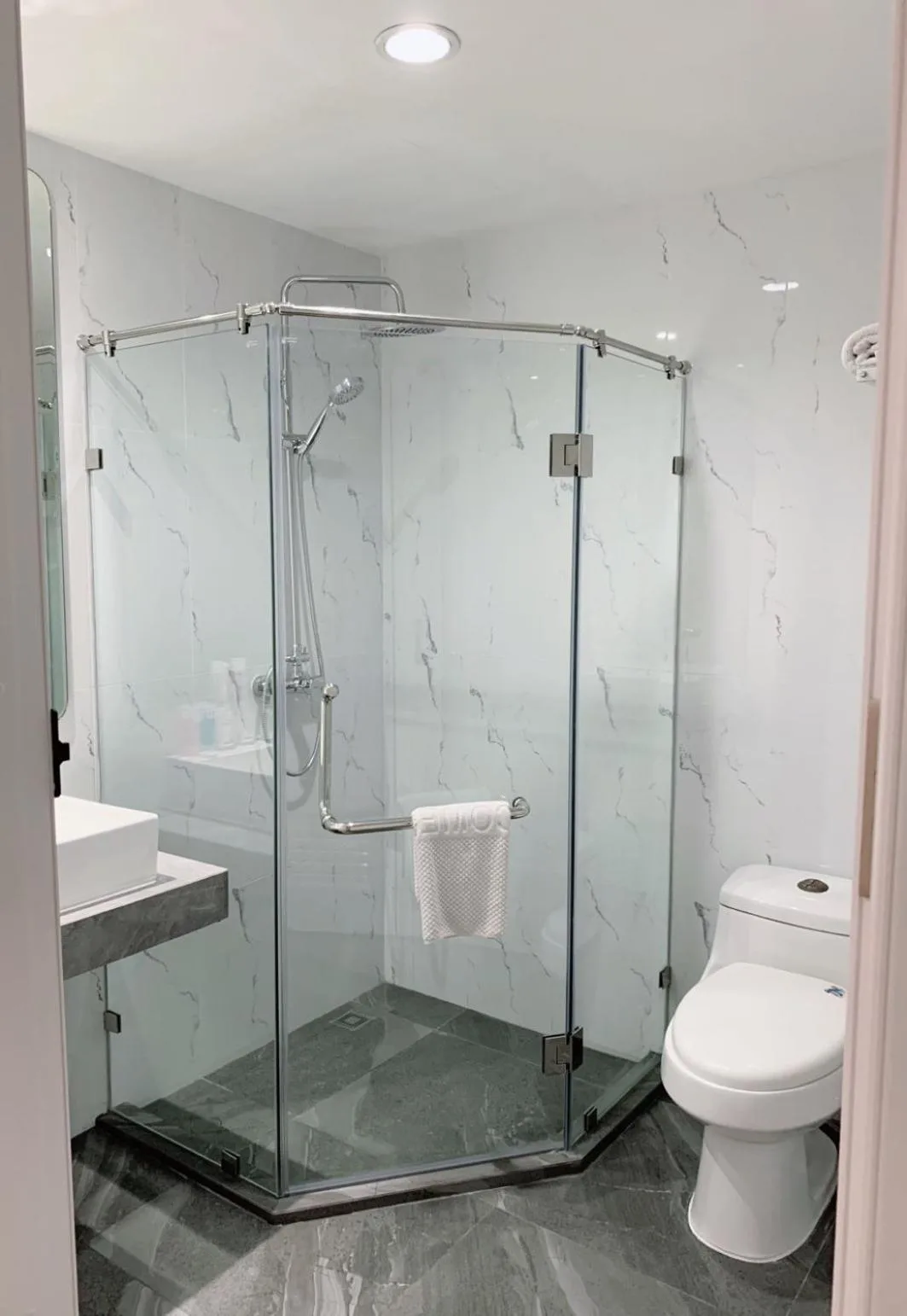 Bathroom amenities at Miloft Sathorn Hotel in Bangkok with toiletries, cups, and sink area