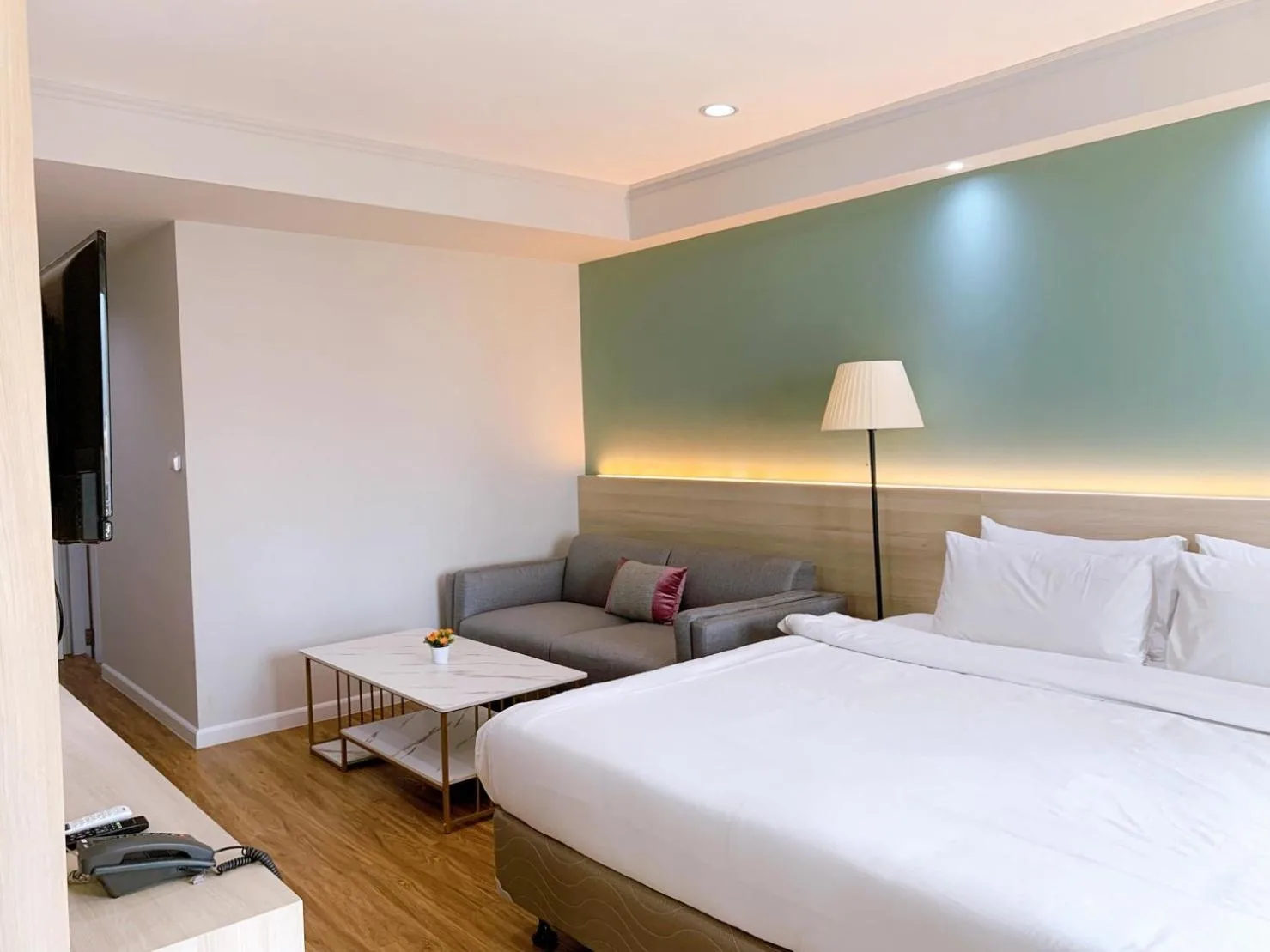 Studio room at Miloft Sathorn Hotel in Bangkok with king bed, sofa, and work table