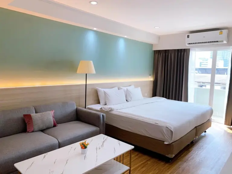 Superior room at Miloft Sathorn Hotel in Bangkok with king bed, sofa, and marble coffee table