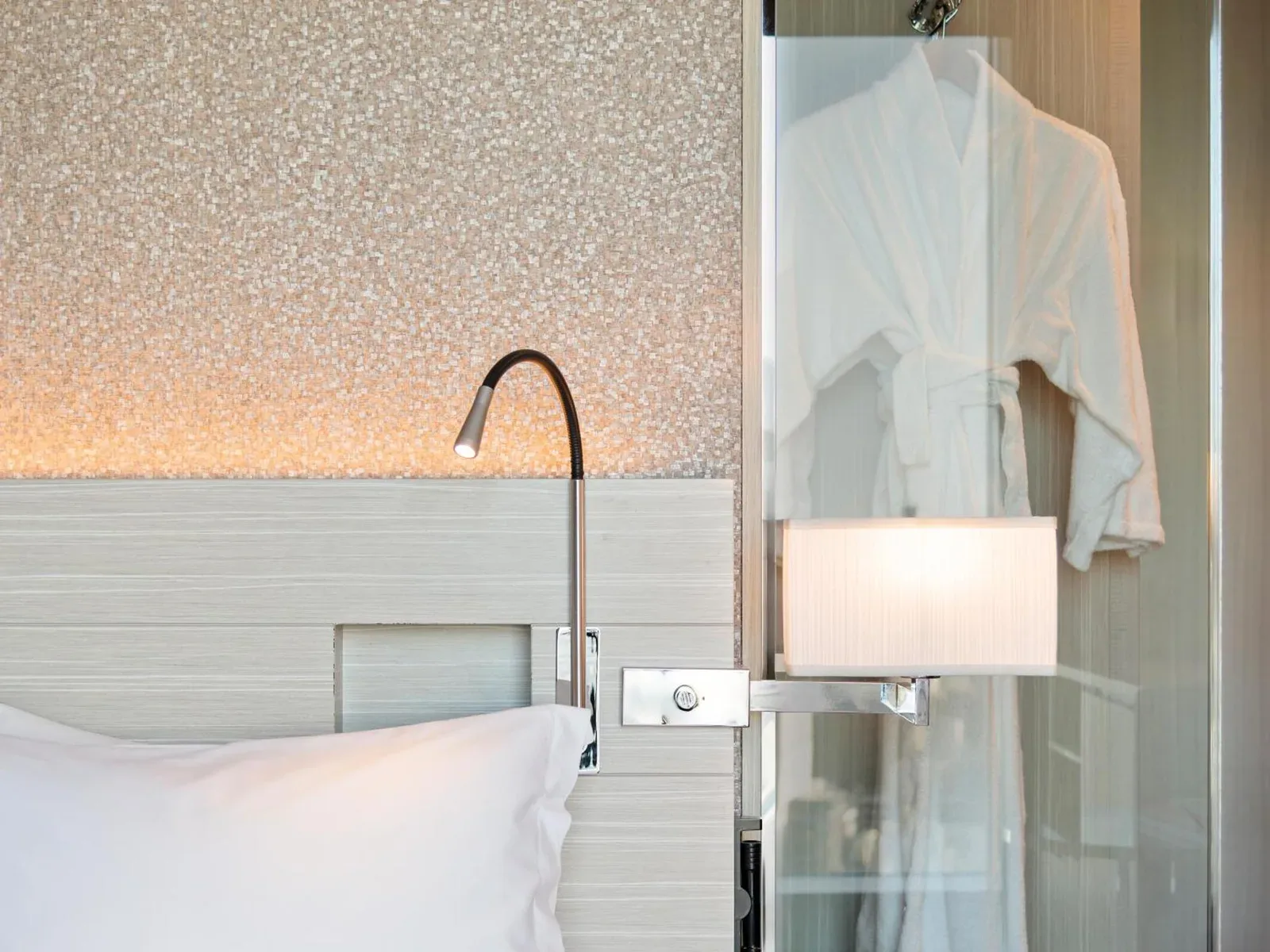 Luz de lectura junto a la cama y albornoz en Mitsui Garden Hotel Ginza Premier