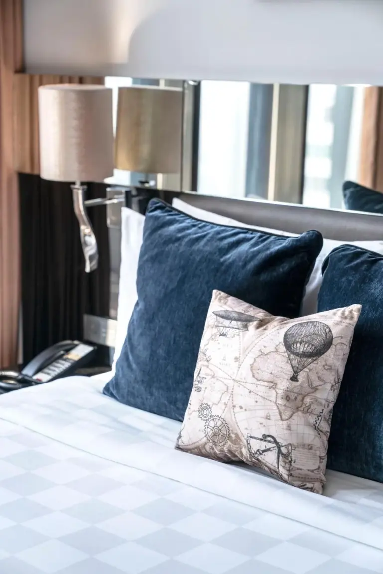 Montraj Continent Sukhumvit Bangkok – Bangkok, Thailand hotel – a bed with blue pillows and a pillow on it at Montraj Continent Sukhumvit Bangkok in Bangkok