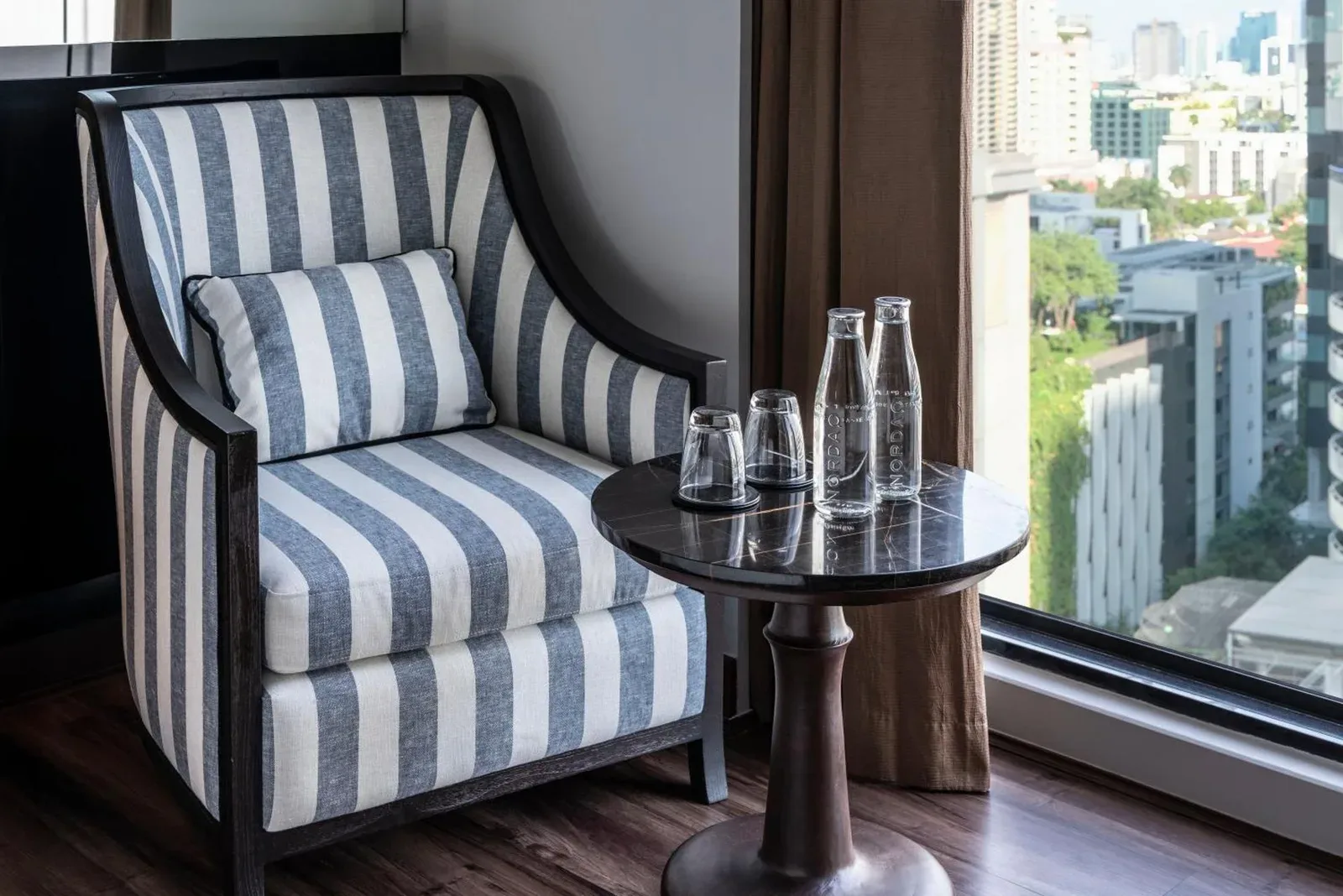 Montraj Continent Sukhumvit Bangkok – Bangkok, Thailand hotel – a chair with a table in a room with a window at Montraj Continent Sukhumvit Bangkok in Bangkok