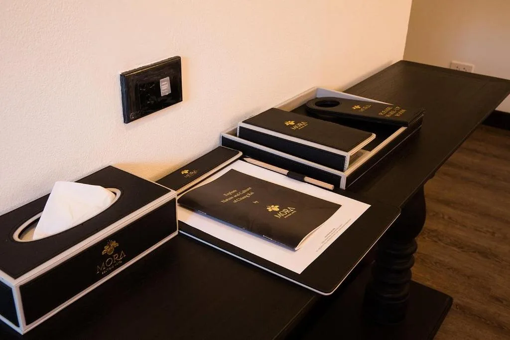 Hotel amenity set at MORA Boutique Hotel Chiang Rai arranged on a dark table