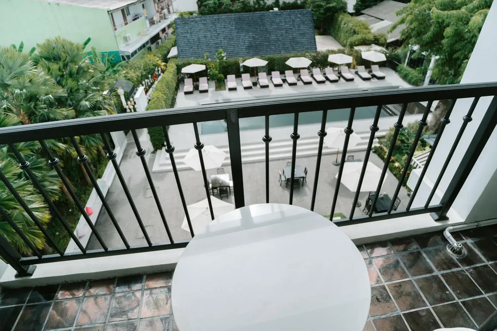 Balcony view from MORA Boutique Hotel Chiang Rai with a small table and greenery outside