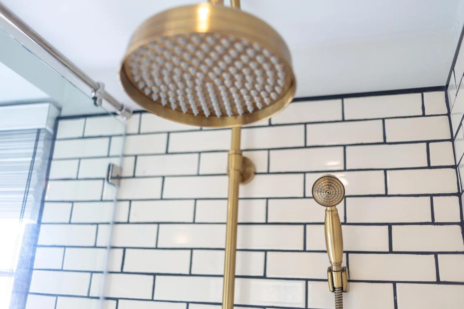 Gold rain shower at MORA Boutique Hotel Chiang Rai with white subway tile wall