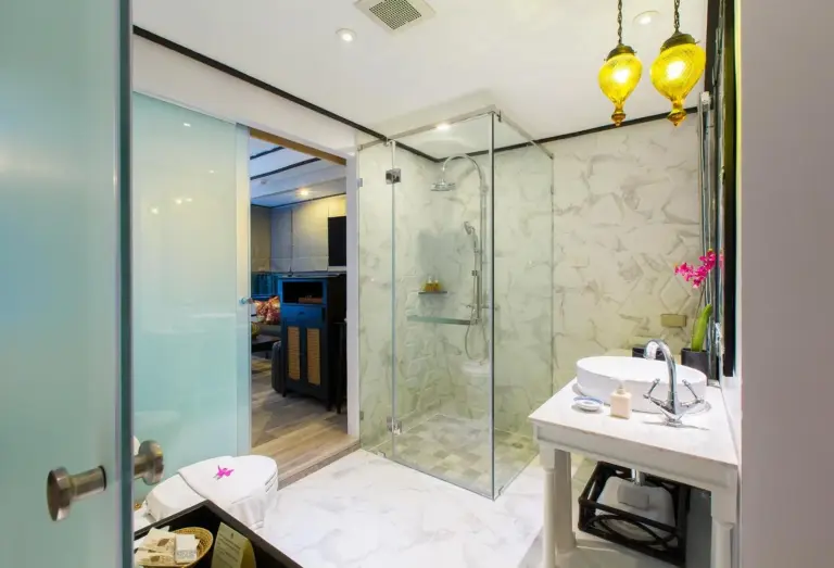 Modern bathroom at Moracea by Khao Lak Resort in Khao Lak with glass shower and vanity