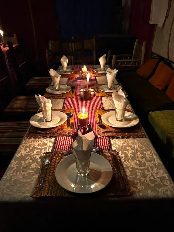 Moroccan Desert Camp in Merzouga candlelit dining table with folded napkins and traditional table setting